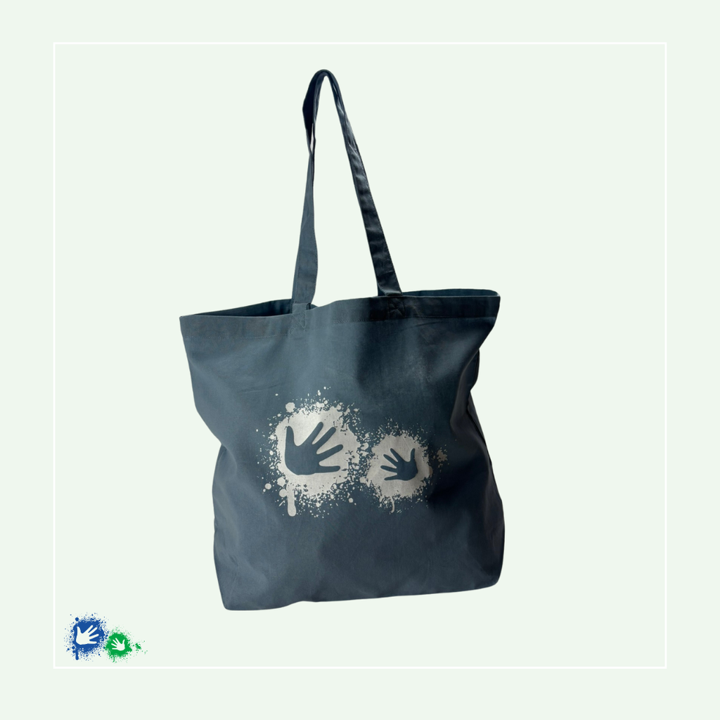 Einkaufstasche in der Farbe "Dusty blue" (blau) von vorne mit dem weißen Hände-Logo.