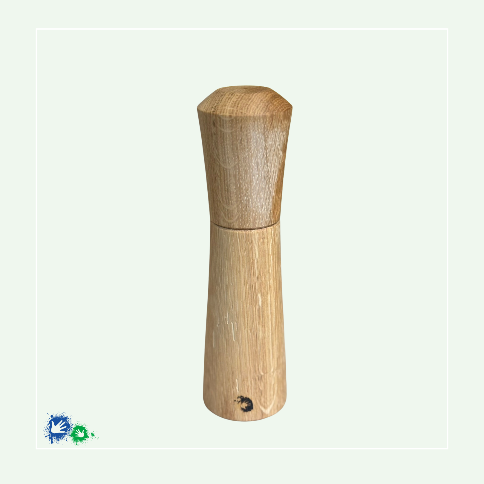 Eine Salz-/Pfeffermühle aus hellem Holz zum Drehen. Im unteren Teil ist ein Hände-Logo eingebrannt.
