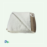 Das Bild zeigt eine zusammengefaltete Kuscheldecke. Die obere Seite ist aufgeklappt und zeigt das wollweiße Kuschelfell. 