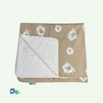 Das Bild zeigt eine zusammengefaltete Kuscheldecke. Die obere Seite ist aufgeklappt und zeigt das wollweiße Kuschelfell. 