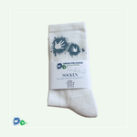 Zusammengefaltete weiße Socken mit hellblauem Hände-Logo. Darum eine Papier-Banderole mit dem Aufdruck: Hände für Kinder Logo, handbedruckte Socken aus dem Neuen Kupferhof, Größe: EUR 39-42, UK 5,5-8, US 7,5-9