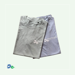 Zwei gefaltete T-Shirts in Pastelltönen liegen leicht überlappend auf einem hellen, mitfarbenem Hintergrund. Das vordere T-Shirt ist dusty-green (grün), das dahinterliegende dusty-blue (blau). Beide tragen auf der linken Brust einen weißen Aufdruck mit Handabdrücken und dem Schriftzug „HÄNDE FÜR KINDER - DER NEUE KUPFERHOF“.